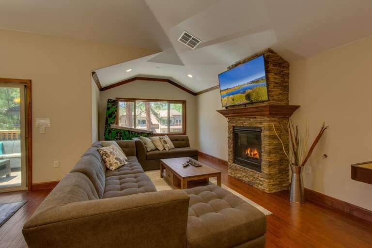 Living area with large sectional sofa, flat screen tv, and fireplace