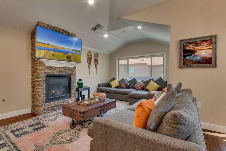 Living area with comfy sectional sofa. large flat screen tv, and fireplace