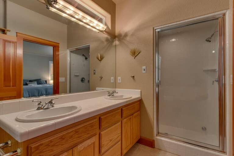 Bathroom with dual sinks and spacious shower