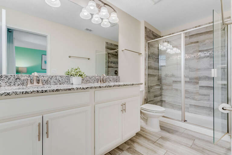 Bathroom with dual sinks and glass enclosed shower