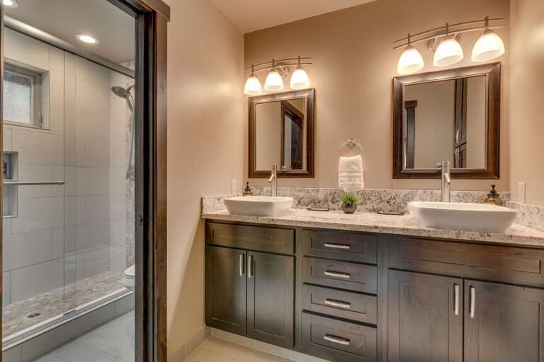 Bathroom with dual sinks and glass enclosed shower