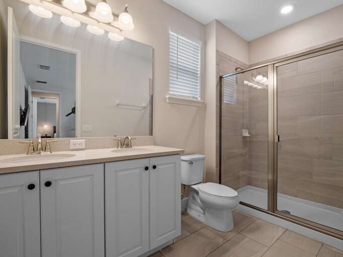 Bathroom with dual sinks and glass enclosed shower Bathroom with dual sinks and glass enclosed shower