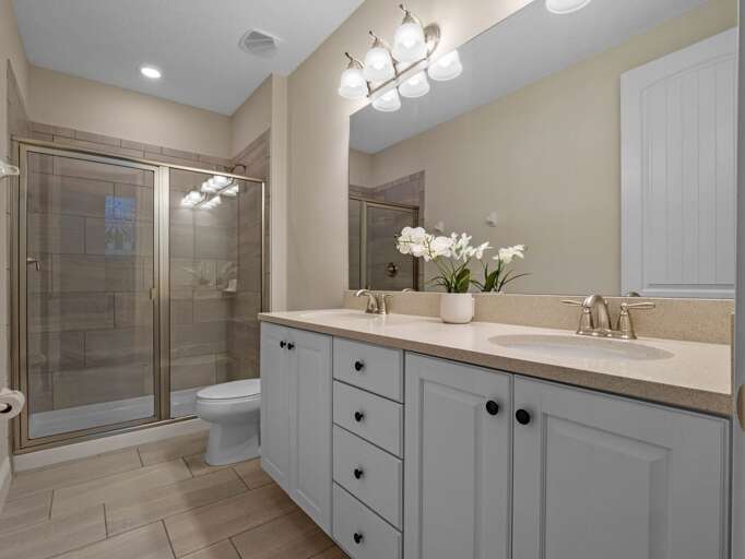 Bathroom with dual sinks and glass enclosed shower Bathroom with dual sinks and glass enclosed shower