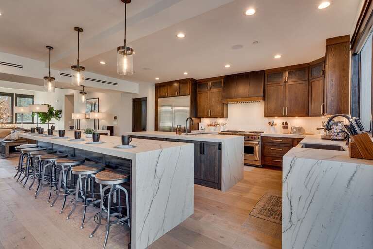 Elegant kitchen with stainless steel appliances, large island, and panoramic views