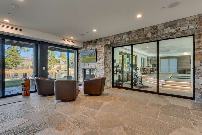 Seating area with lake side view, flat screen TV, and fireplace