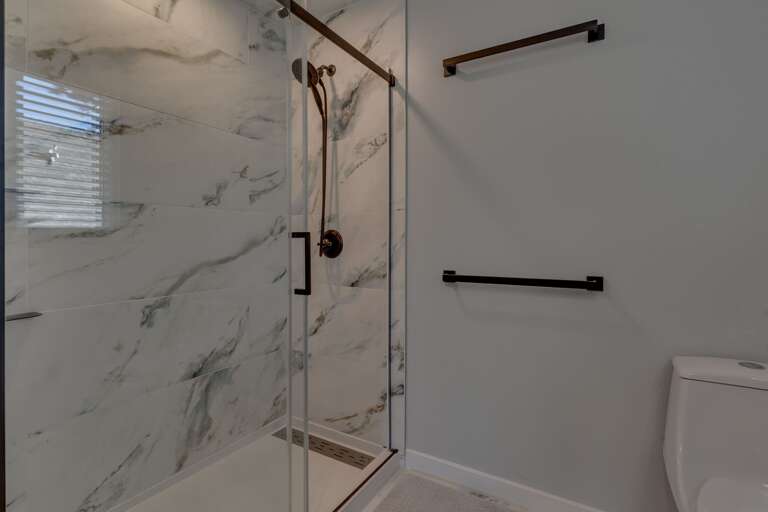 Bathroom with dual sinks and glass enclosed shower