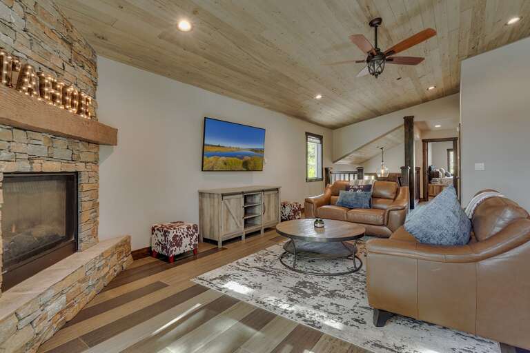Living area w/ comfy couch, flat screen TV, and fireplace