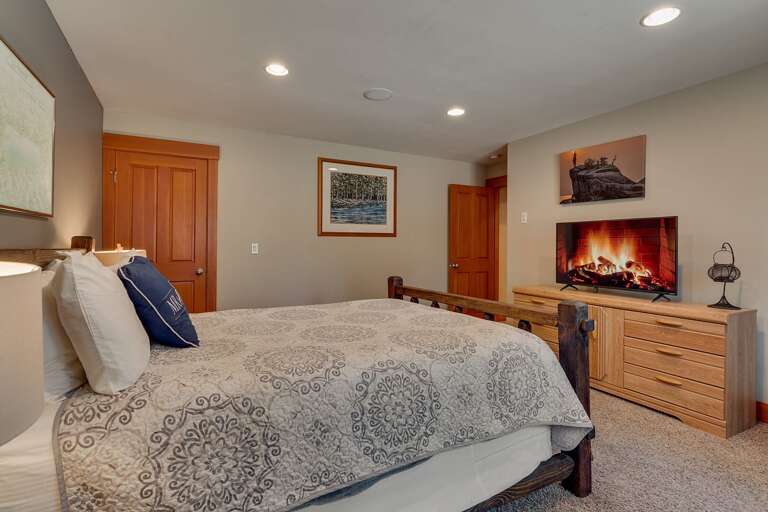 - Comfortable king bedroom with dresser and TV
- Cozy retreat with rustic furnishings and calming tones
- Convenient downstairs location near entertainment areas