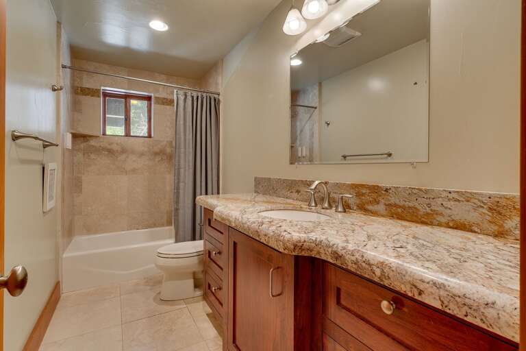 - Full downstairs bathroom with shower and tub combination
- Granite vanity countertops with storage space below
- Conveniently located near the downstairs entertainment and guest bedroom