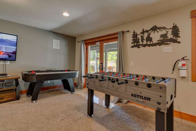 - Game room with foosball table and air hockey
- Fun entertainment space with TV and outdoor access
- Perfect for family game nights