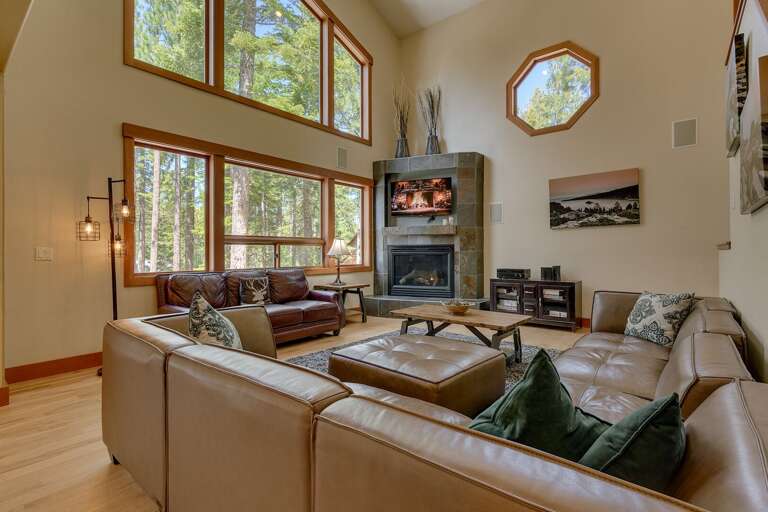 - Living room with soaring windows and forest views
- Cozy fireplace lounge with comfortable seating
- Bright open living spaces