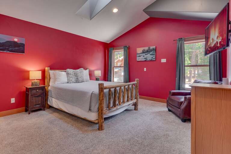 - Upstairs bedroom with queen bed
- Vaulted ceilings and large windows for a bright, open feel
- Cozy retreat with TV, seating area, and soft carpeting throughout