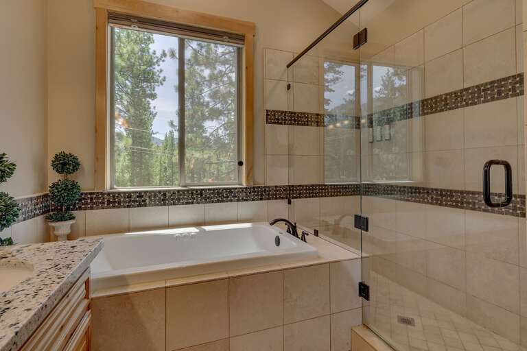 Bathroom w/ dual sinks and glass enclosed shower