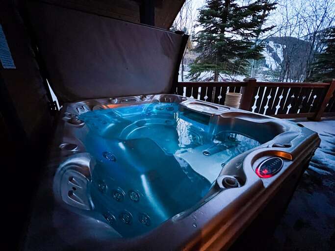 Outdoor Bubbling Blue Jacuzzi On Balcony At Twilight
