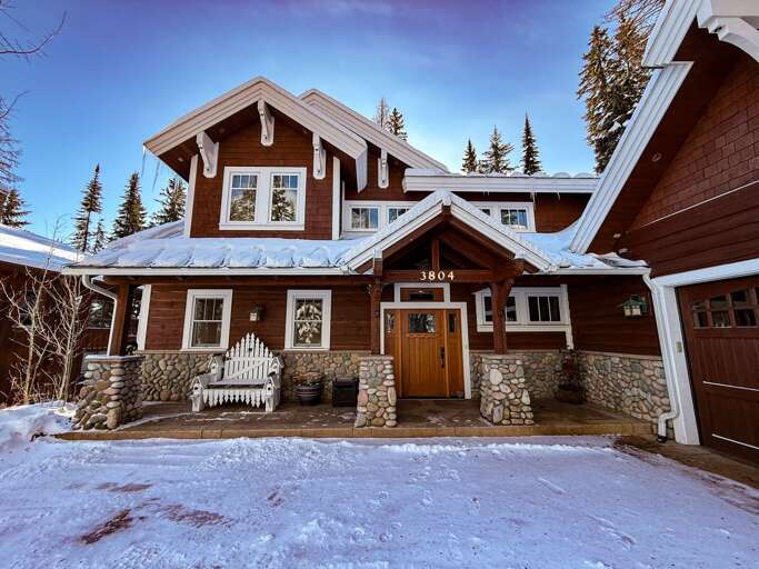 Snow-dusted Lodge Surrounded By Serene Spruces