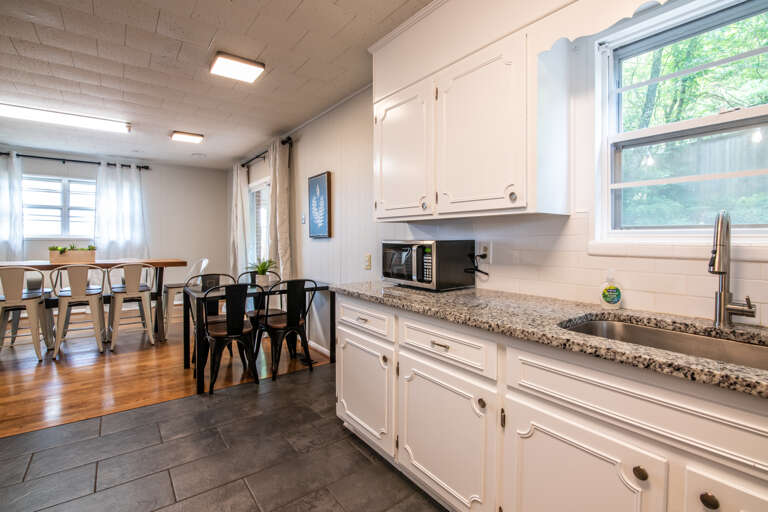 The kitchen is equipped with a microwave, stove, oven, fridge, and plenty of utensils.