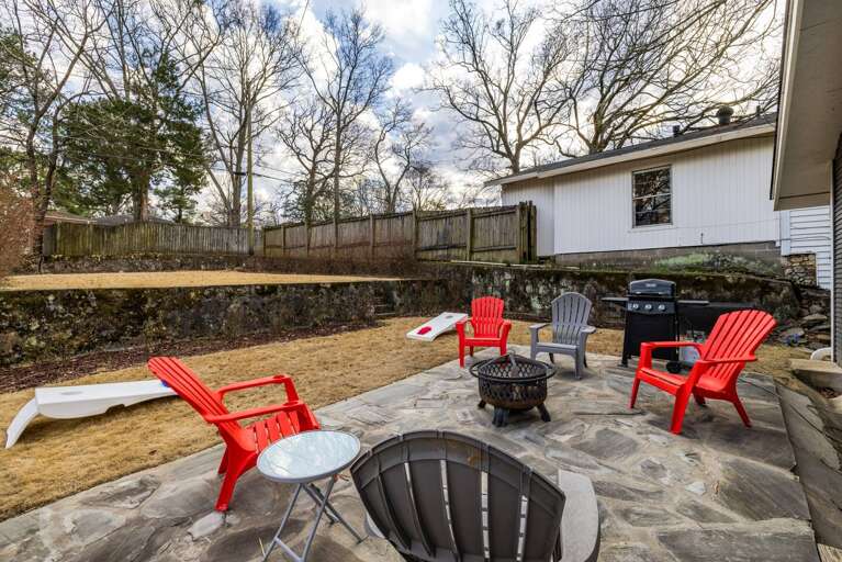 Large backyard equipped with a fire pit, grill, and plenty of room for activities. Large backyard equipped with a fire pit, grill, and plenty of room for activities.