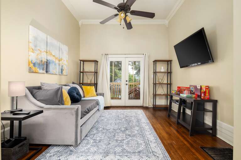 The third bedroom in your Airbnb offers versatility, with a comfortable daybed for relaxation and a TV.