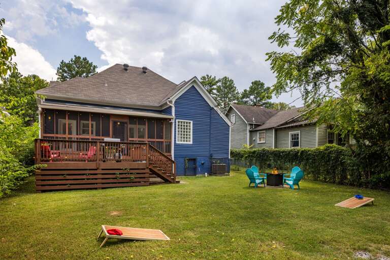 Enjoy the spacious backyard, complete with a fun corn hole game setup, providing a perfect outdoor activity for guests of all ages.