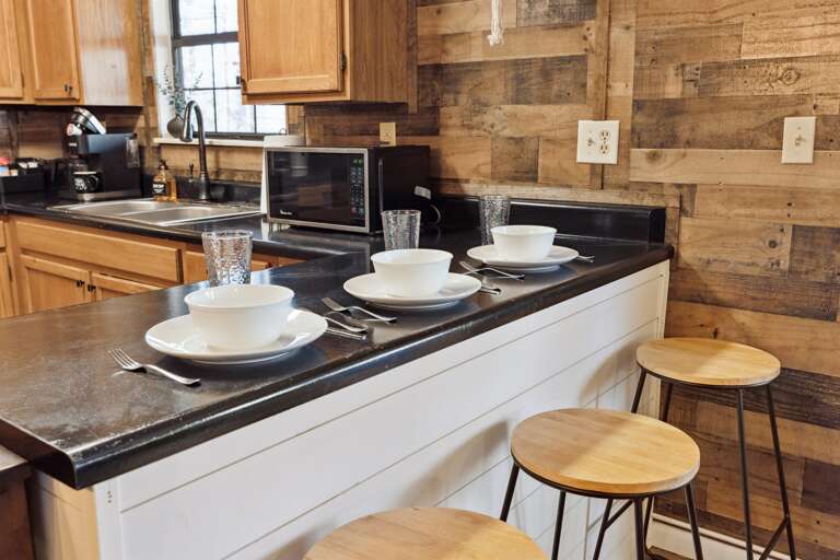 Enjoy the convenience of dining and socializing at our trendy bar counter with three rustic stools.