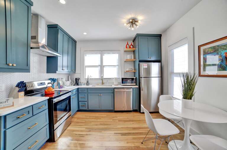 **Kitchen Chic**: Bright blue cabinets and orange accents bring a vibrant energy to the kitchen, making it a delightful space for culinary creativity.