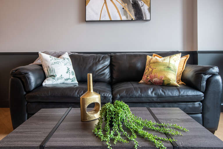 The heart of our home: a direct view into our inviting living room with its statement coffee table and luxurious black leather couch.