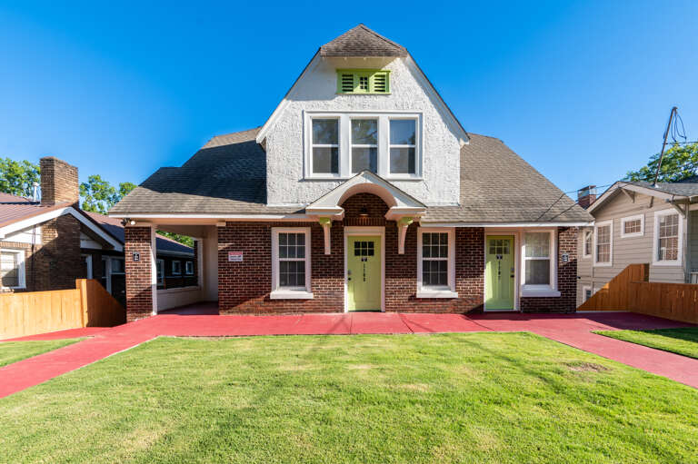 Welcome to your peaceful retreat, highlighted by lush green grass and a welcoming red sidewalk. Dreaming of more escapes? Discover more with Legacy Stays. www.legacystays.org