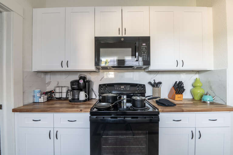 Discover the joy of cooking in our kitchen, featuring extensive cookware, stove, oven, and microwave for your dining pleasures.