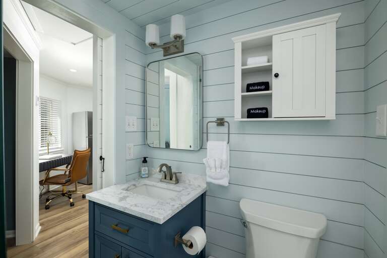 Experience the downstairs bathroom's luxury, highlighted by marble accents and equipped with an array of premium shower condiments for a truly pampering retreat.