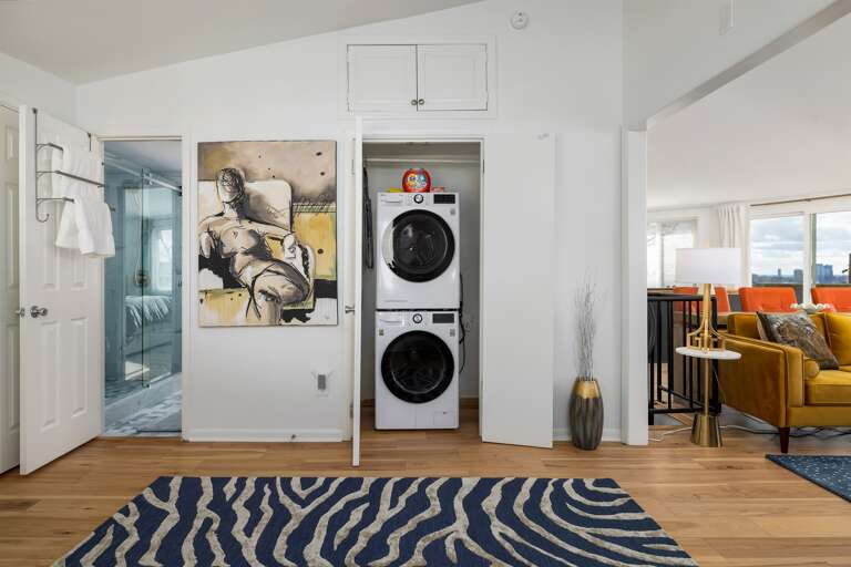 Modern art adorns each turn, leading to a functional laundry space, blending aesthetics with practicality in every corner.