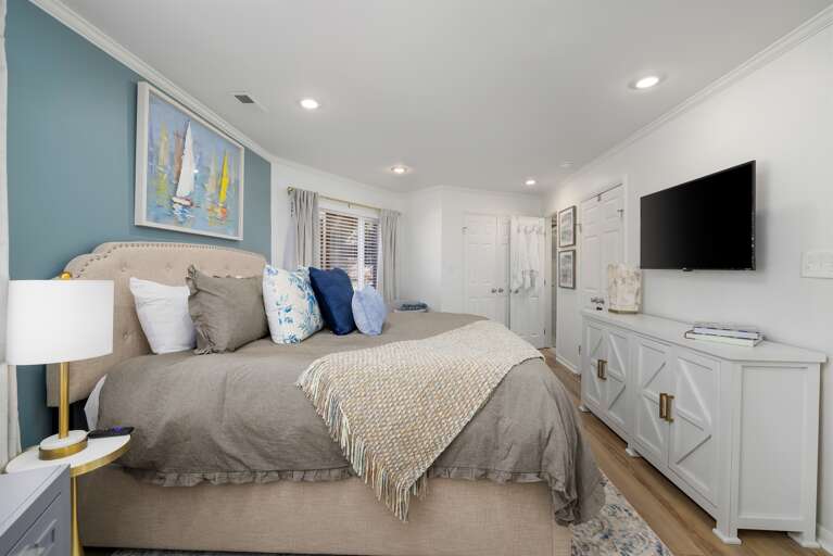Retreat to the downstairs king suite, boasting a smart TV for entertainment at your fingertips, ample storage for convenience, and cozy linens ensuring a restful night.