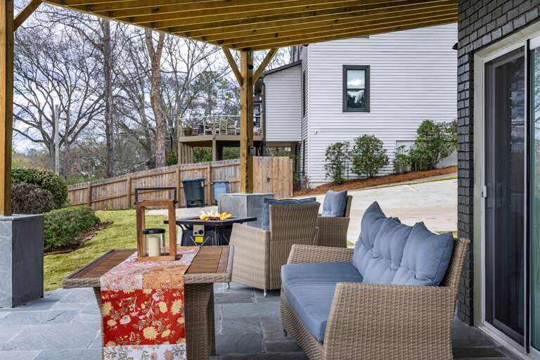 Enjoy al fresco dining at its finest with a stylish table amidst plush blue cushions, creating an exquisite outdoor seating arrangement.