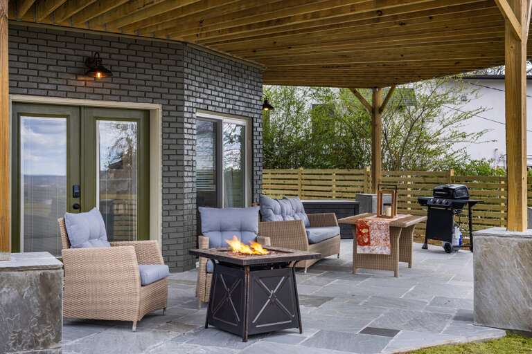 Enjoy the main level's outdoor patio, complete with a gas firepit and grill, surrounded by comfy furniture. It's the ideal spot for relaxing or entertaining under the open sky.