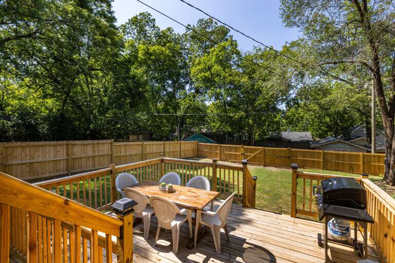 Backyard with Large Deck, Gas Grill, Outdoor Dining Space: The expansive backyard features a large deck with a gas grill and outdoor dining space, perfect for al fresco meals and entertaining.