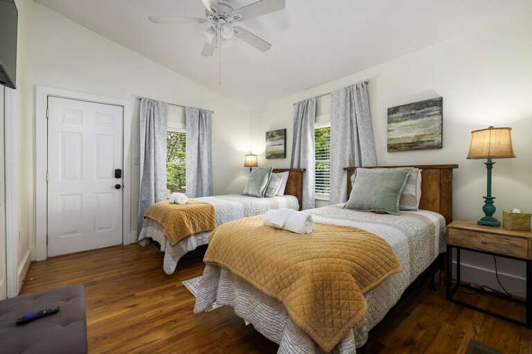 Another angle of the twin bedroom highlights the cheerful decor and convenient storage options, ensuring a pleasant stay for guests.