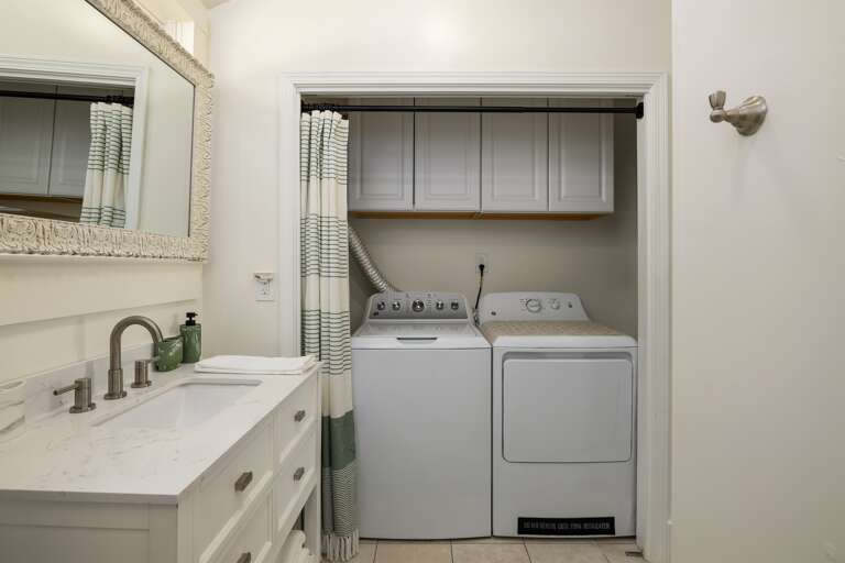 This bathroom includes convenient laundry facilities, making it easy to keep up with any washing needs during your stay. 