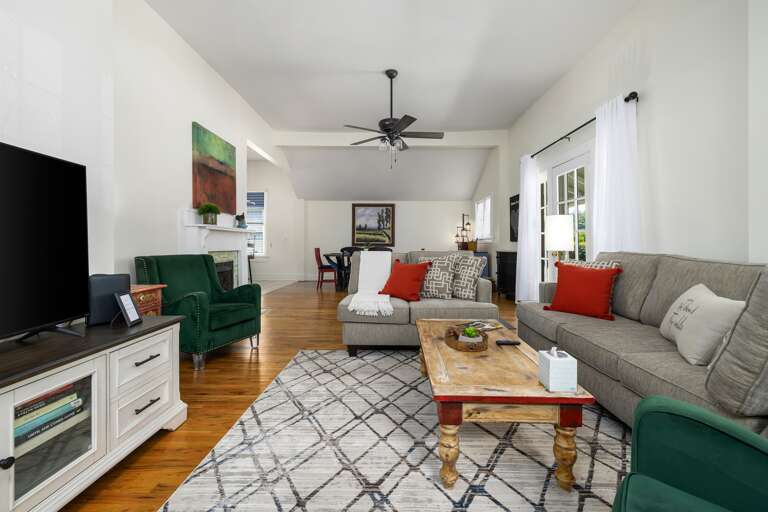 Another angle of the living room showcases the ample seating available, perfect for gathering with family or friends. The room is filled with natural light, creating a warm and welcoming environment. 