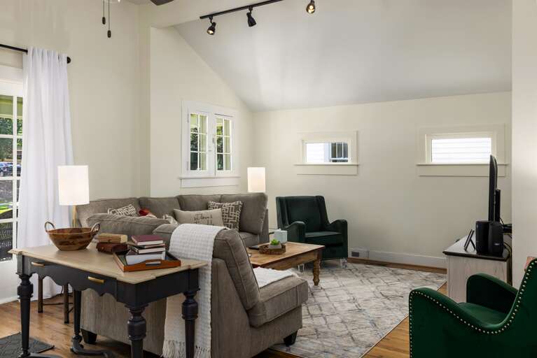 The spacious living room features a blend of comfort and style with plush seating, tasteful decor, and a large smart TV. It's an ideal space for relaxation and entertainment. 