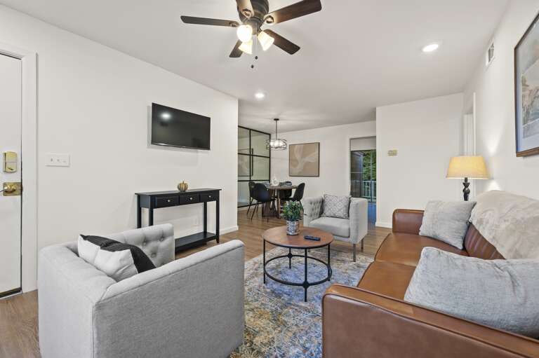 Cozy living room featuring a smart TV for streaming your favorite shows. Relax in comfortable seating with stylish decor, perfect for unwinding after a day of adventures. Ample natural light and modern amenities create a welcoming atmosphere.