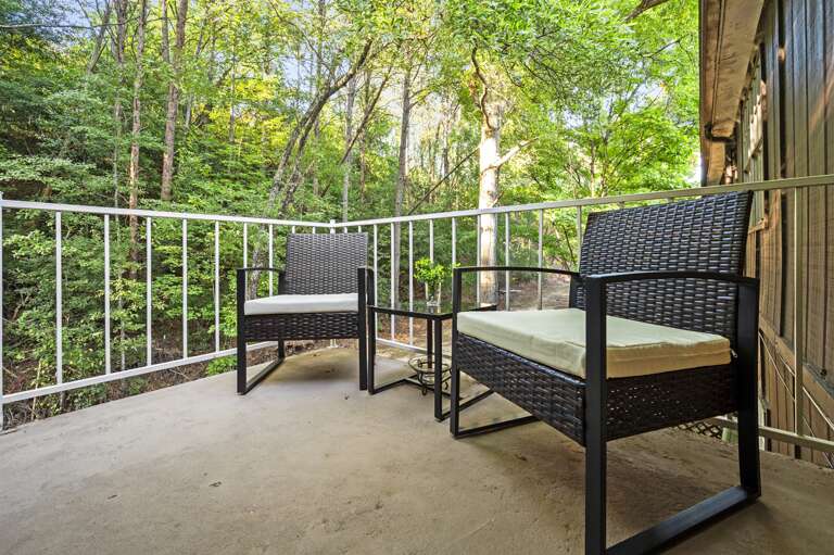 Cozy patio featuring two inviting chairs, perfect for sipping morning coffee or enjoying the evening breeze. Surrounded by lush greenery, this peaceful spot offers a serene escape for relaxation and unwinding during your stay.
