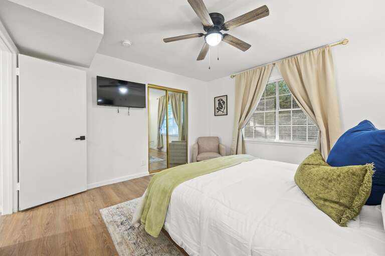 Relax in our plush queen bedroom adorned with calming blues and greens. Enjoy modern comforts with a smart TV for entertainment. A serene getaway perfect for unwinding and recharging.