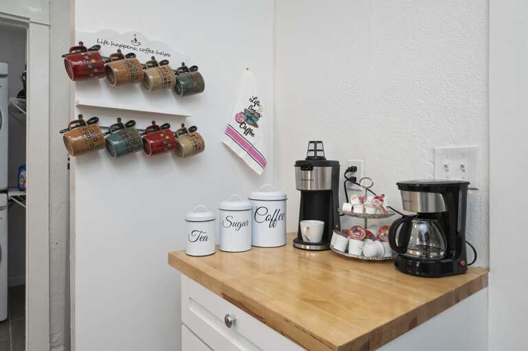 Enjoy a coffee station with tea, sugar, coffee, an instant coffee machine, and a coffee pot.