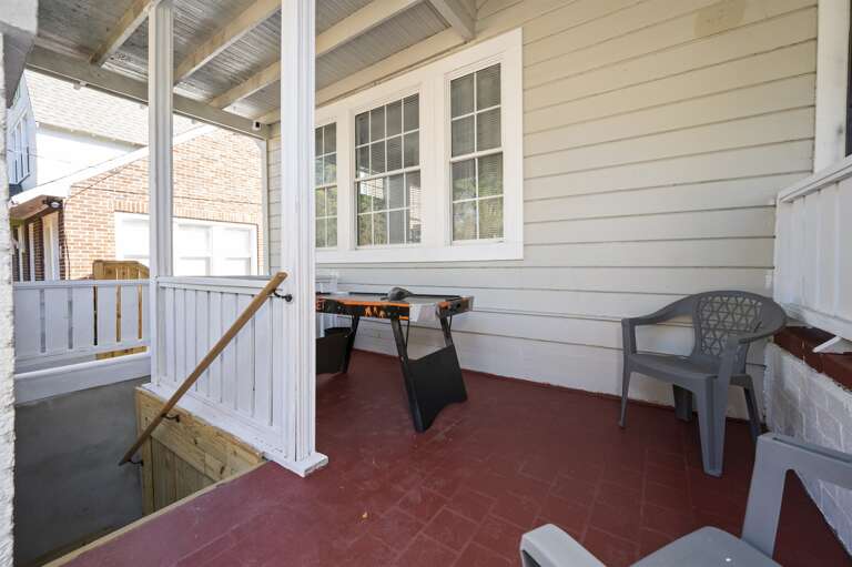 Unit B's inviting front porch with games and wooden stairs leading down to the unit.