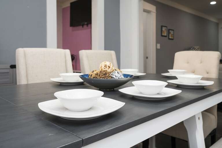 Dining room in Unit B set for eight, offering beautiful, thoughtfully arranged place settings.