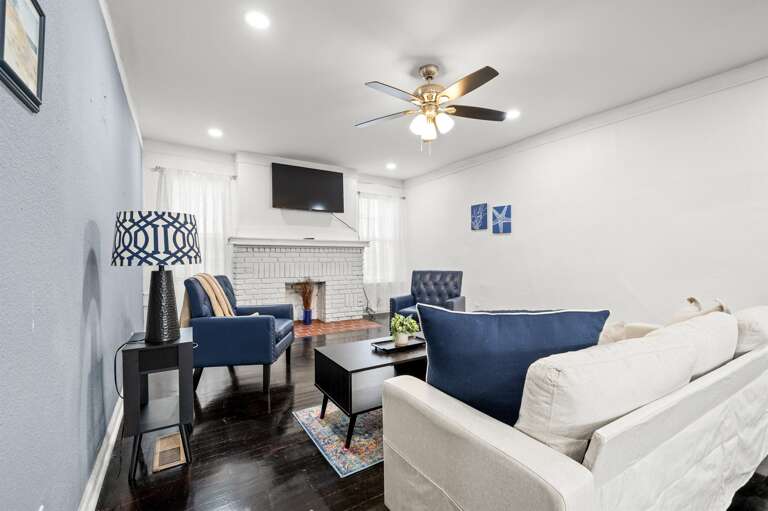 Living room with a cream sofa, two cozy armchairs, and a smart TV for relaxing entertainment.