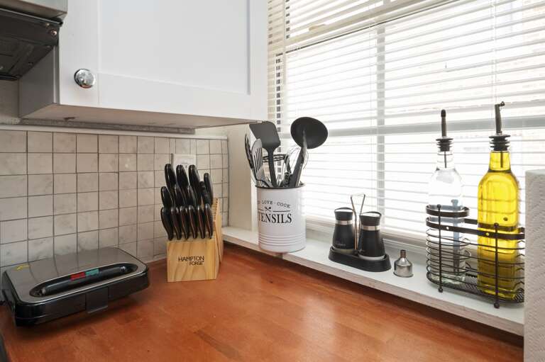 Kitchen stocked with utensils, knives, and cooking oil, ready for meal preparation. Kitchen stocked with utensils, knives, and cooking oil, ready for meal preparation.