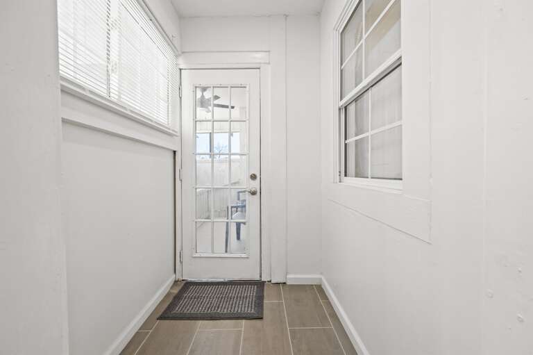 Bright kitchen hallway leading to a screened-in back patio, perfect for relaxation. Bright kitchen hallway leading to a screened-in back patio, perfect for relaxation.