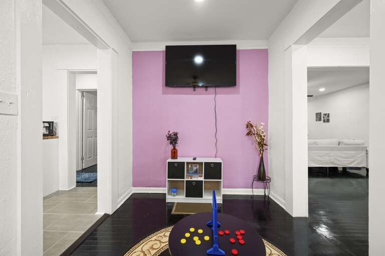 Game room equipped with a Wii console, board games, books, and a cozy gaming setup.