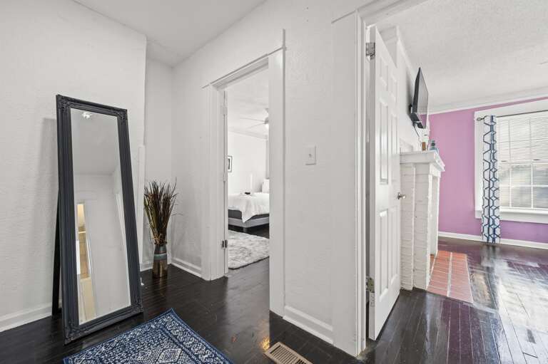 Hallway with a full-length mirror leading to the double full guestroom and queen master bedroom.