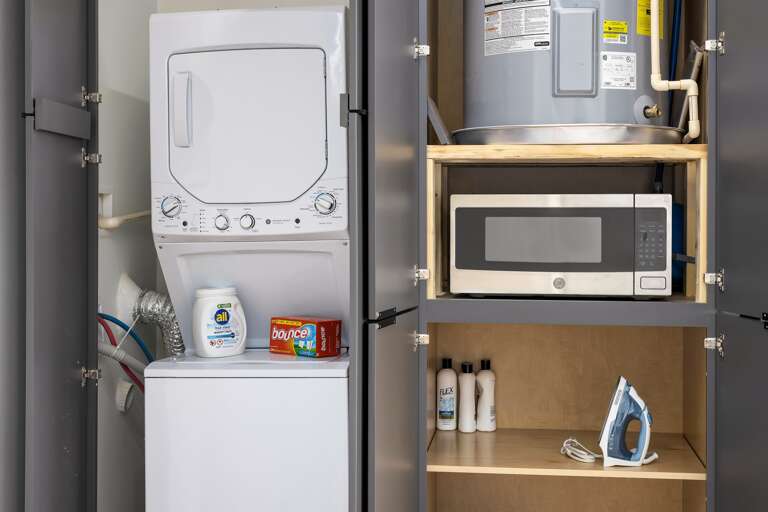 Convenient and practical—this laundry area offers an in-unit washer and dryer for hassle-free laundry during your stay, along with additional storage space for essentials.